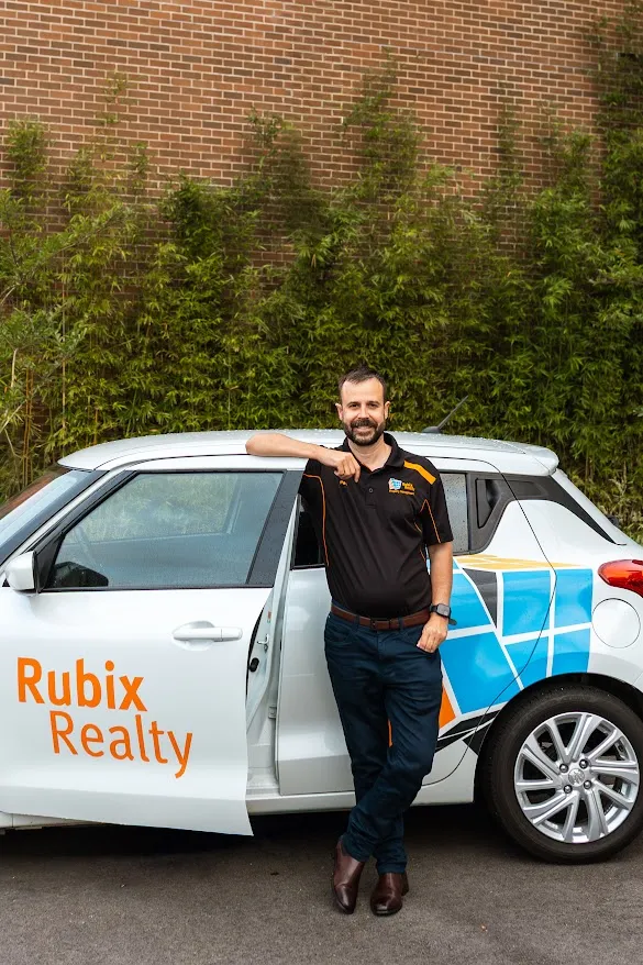 Pat Mears beside the Rubix Realty car, ready for inspections